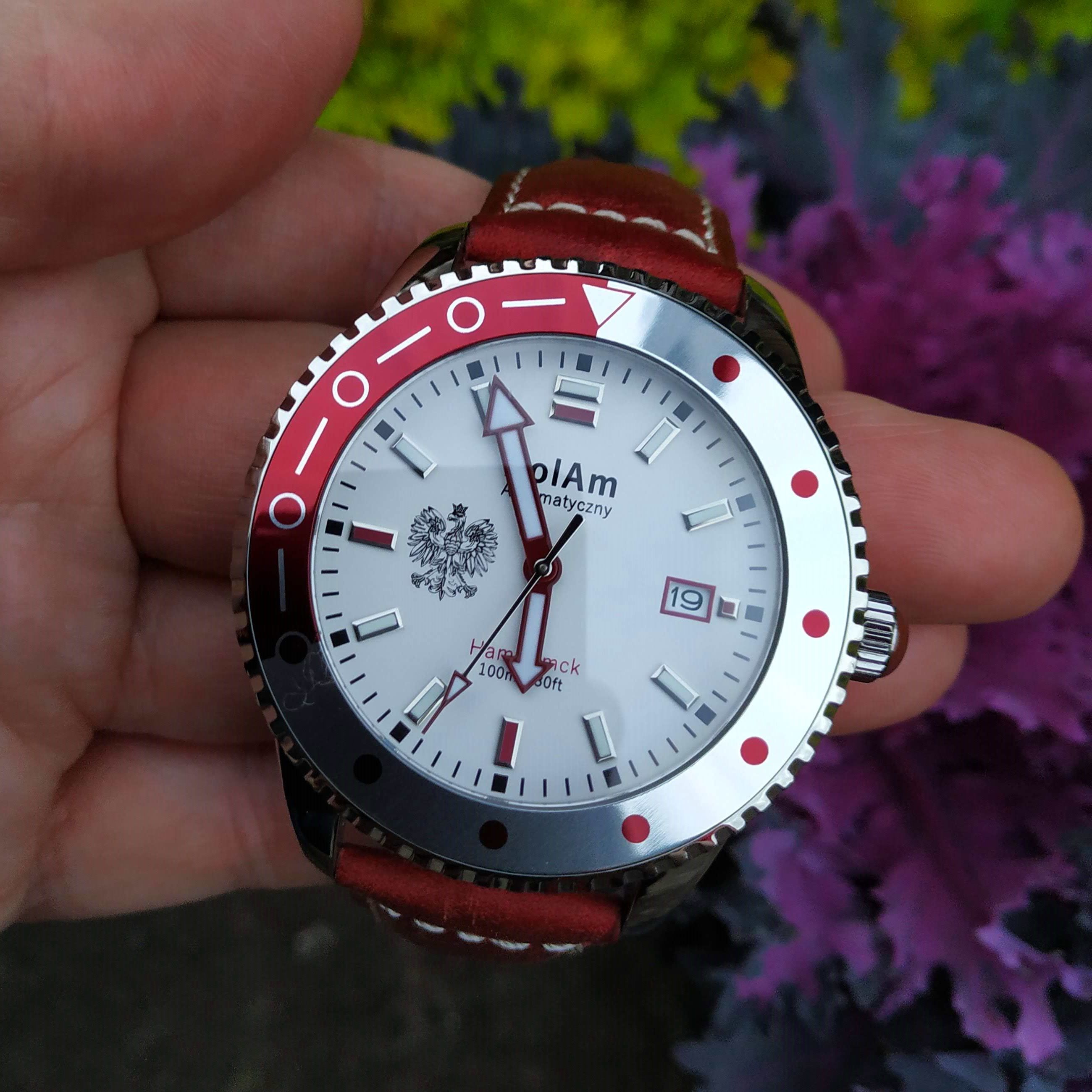 PolAm Hamtramck dive watch with Polish Eagle dial, red and white bezel, held in hand showing the Seiko NH35A automatic movement